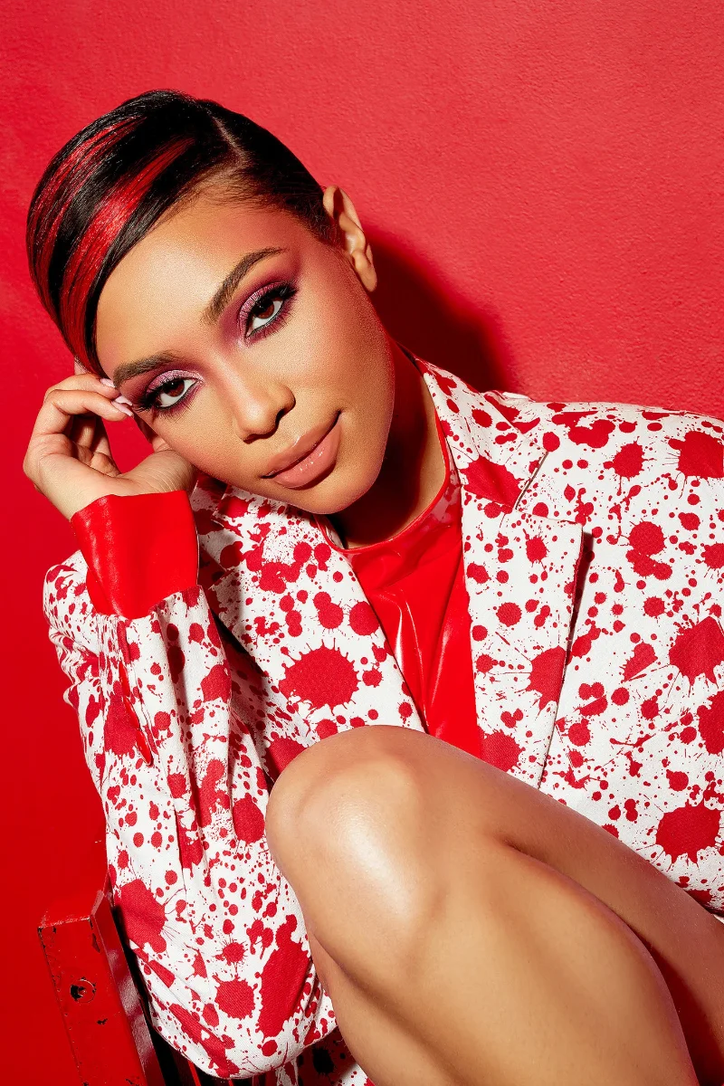 Commercial editorial fashion portrait retouching of a model in a red and white patterned suit on a red background