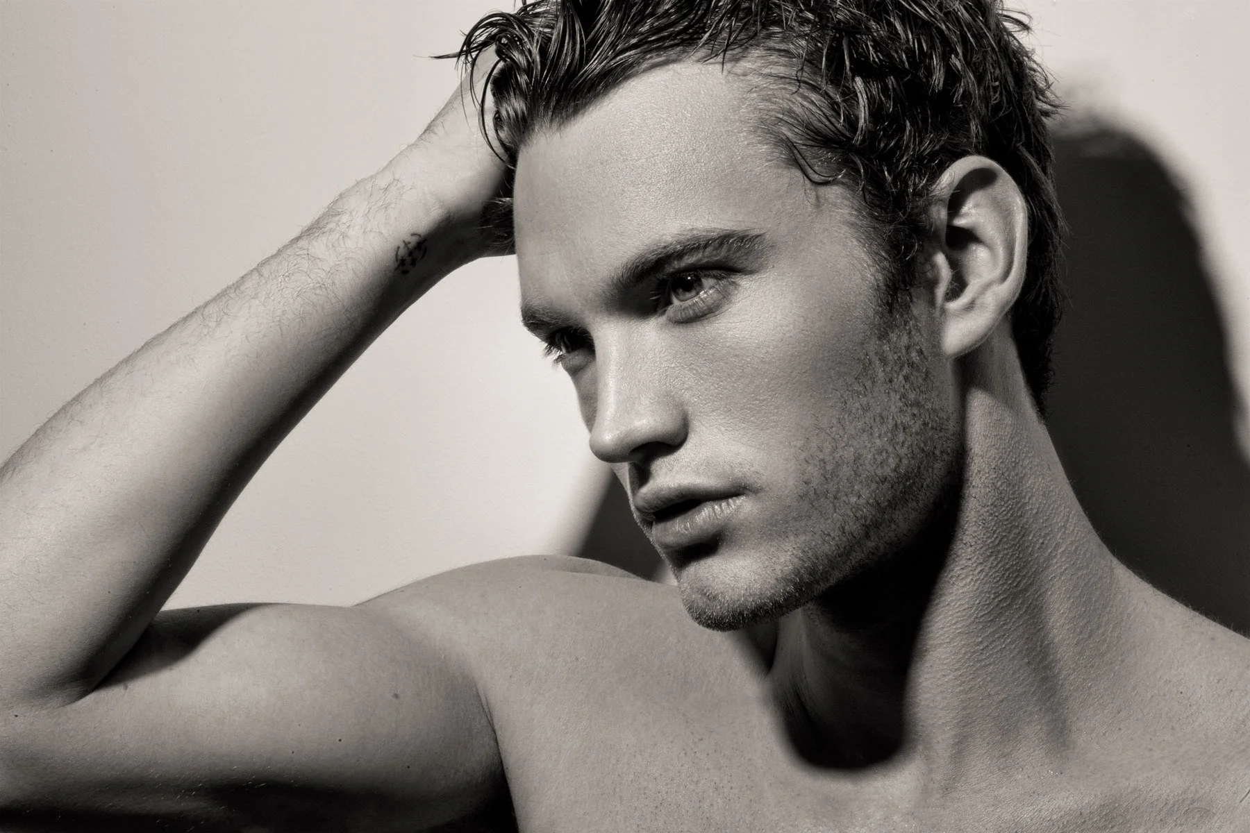 High-end black and white commercial portrait retouching of a male model with wet hair